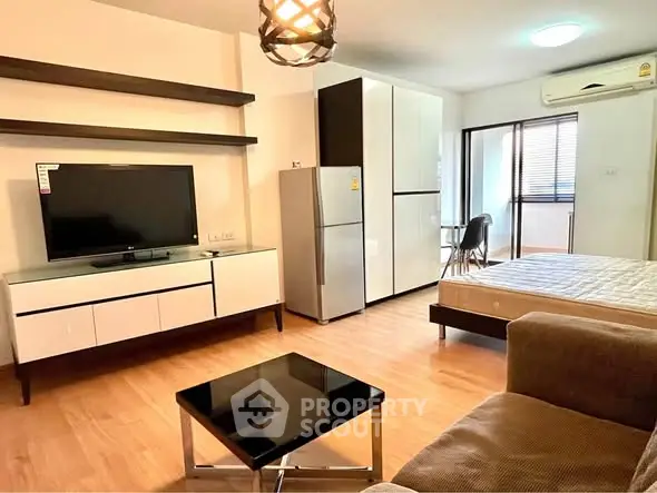 Modern studio apartment with open layout, featuring a cozy living area, sleek kitchen, and stylish furnishings.