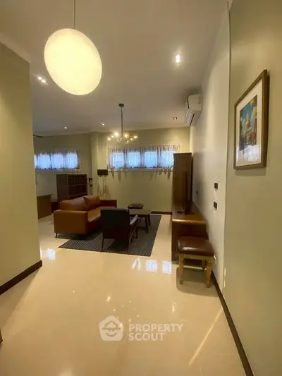Spacious living room with modern furniture and elegant lighting, perfect for relaxation and entertainment.