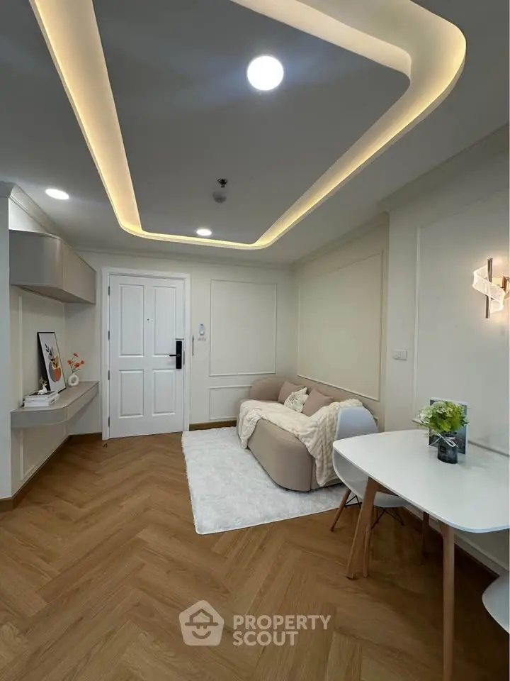 Modern living room with stylish lighting and cozy seating area, featuring elegant wood flooring and contemporary decor.
