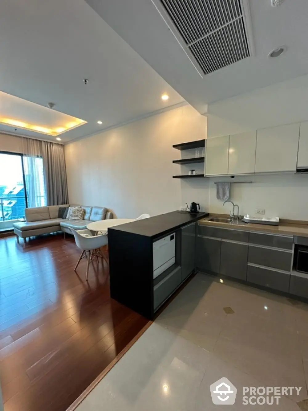 Modern open-layout kitchen and living room with sleek design and natural light.