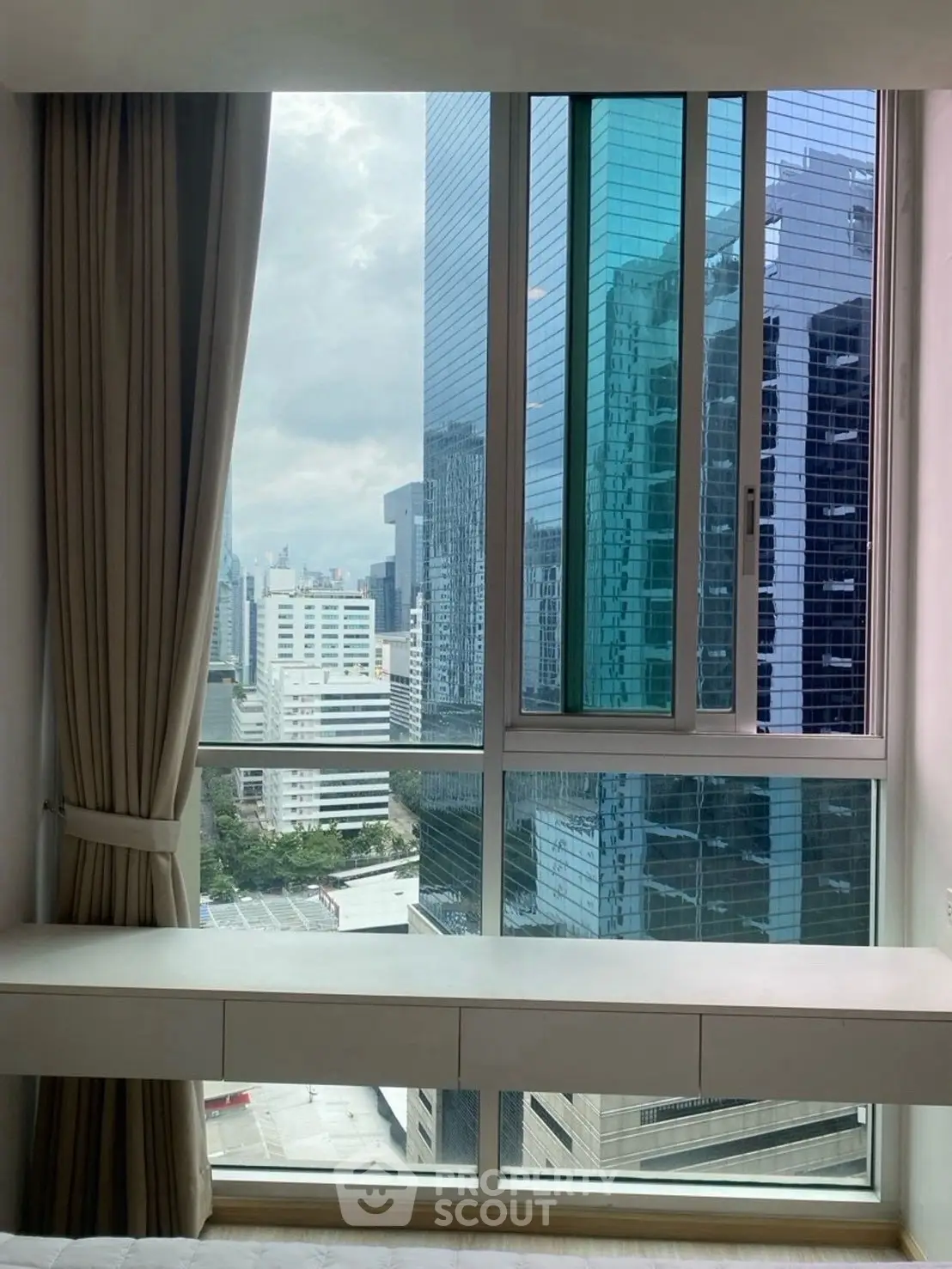 Stunning city view from high-rise apartment window with modern architecture.