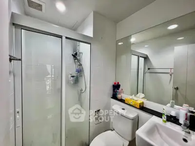 Modern bathroom with glass shower and sleek fixtures in contemporary home.
