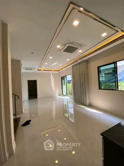 Spacious modern living room with sleek ceiling design and large windows