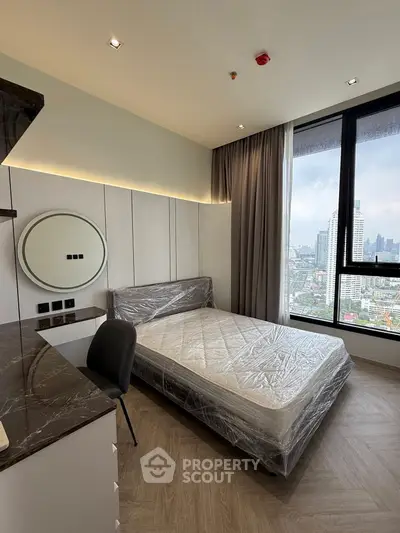 Modern bedroom with city view, featuring sleek design and large window for natural light.