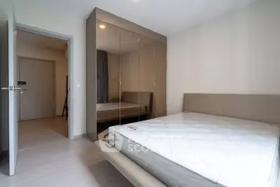 Modern bedroom with sleek mirrored wardrobe and minimalist design