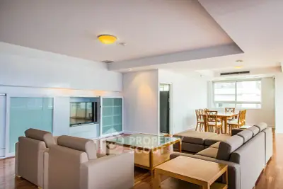 Spacious modern living room with elegant furniture and dining area, featuring natural light and sleek design.