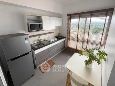 Modern kitchen with sleek cabinets, large window, and dining area offering a scenic view.