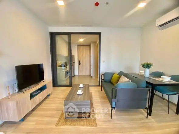 Modern living room with stylish furniture and open kitchen layout in a contemporary apartment.