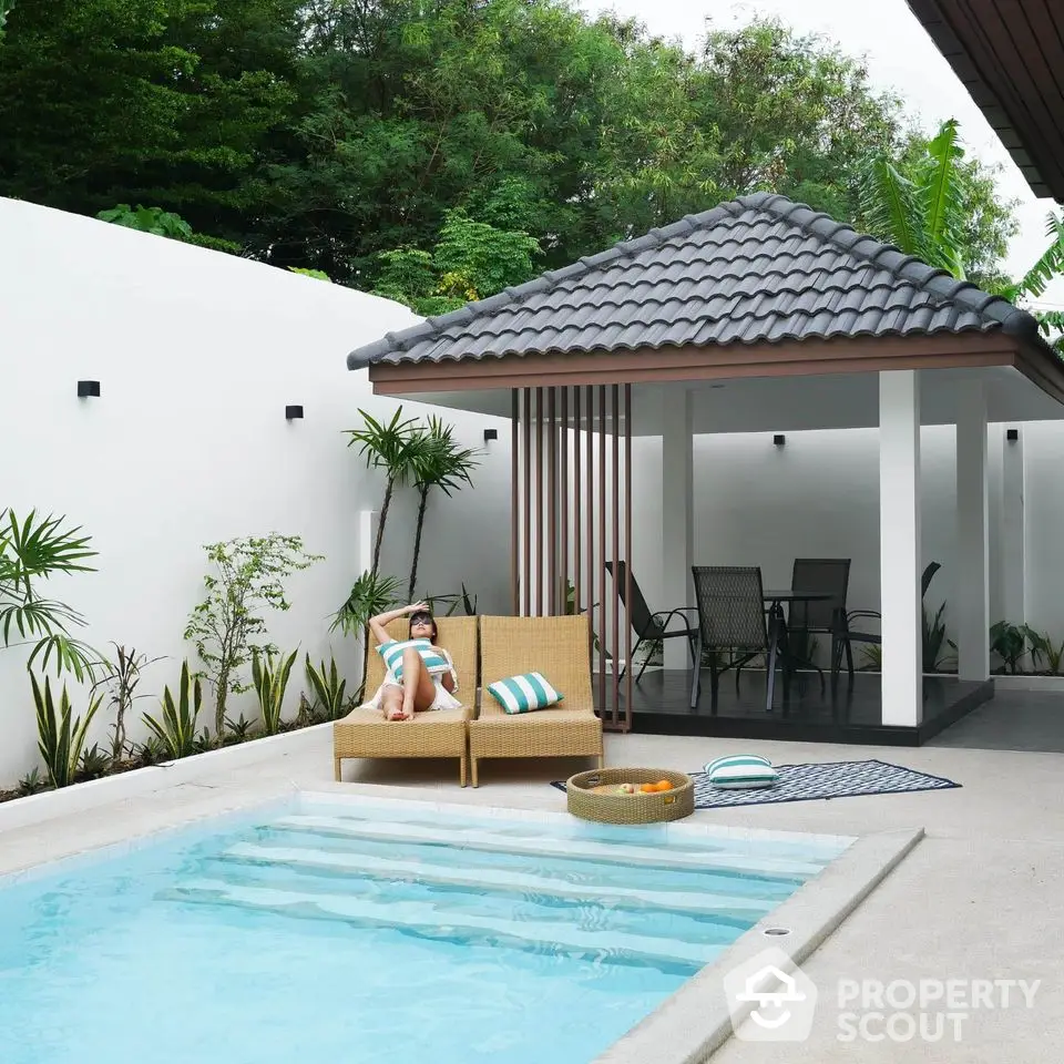 Luxurious private pool with modern gazebo and lush greenery in serene backyard setting.