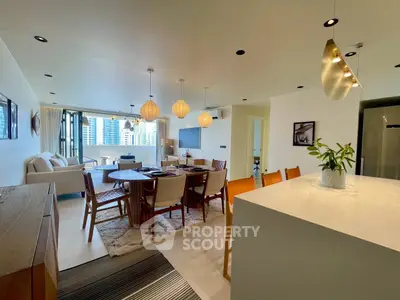 Spacious modern living room with open kitchen and stylish decor in a high-rise apartment.
