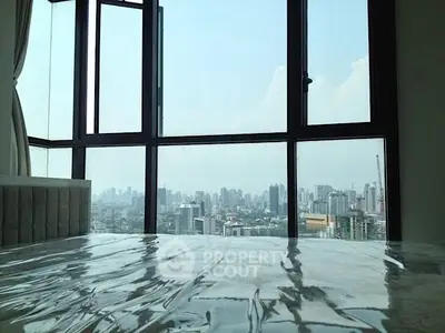 Stunning city view from a modern high-rise apartment bedroom with large windows.