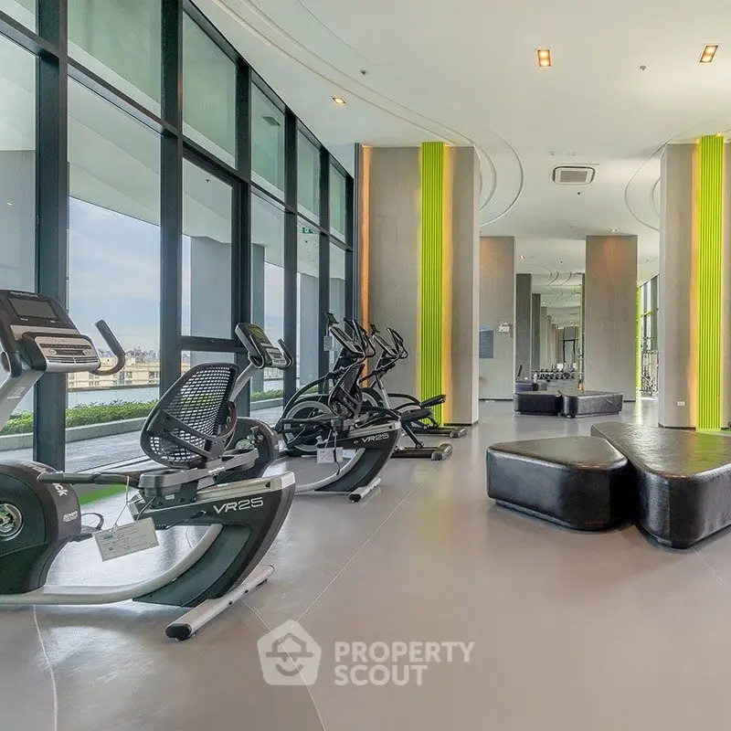 Modern gym with panoramic windows and state-of-the-art fitness equipment in luxury building.