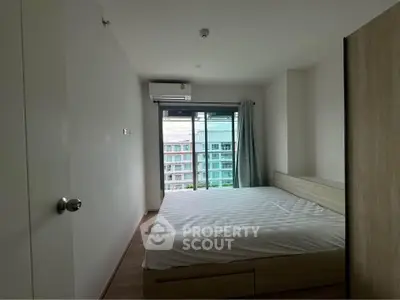 Modern bedroom with large window and city view in contemporary apartment