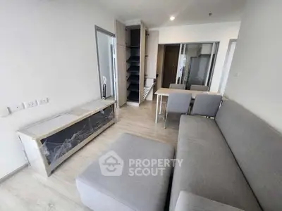Modern living room with gray sofa and open shelving in a minimalist apartment.