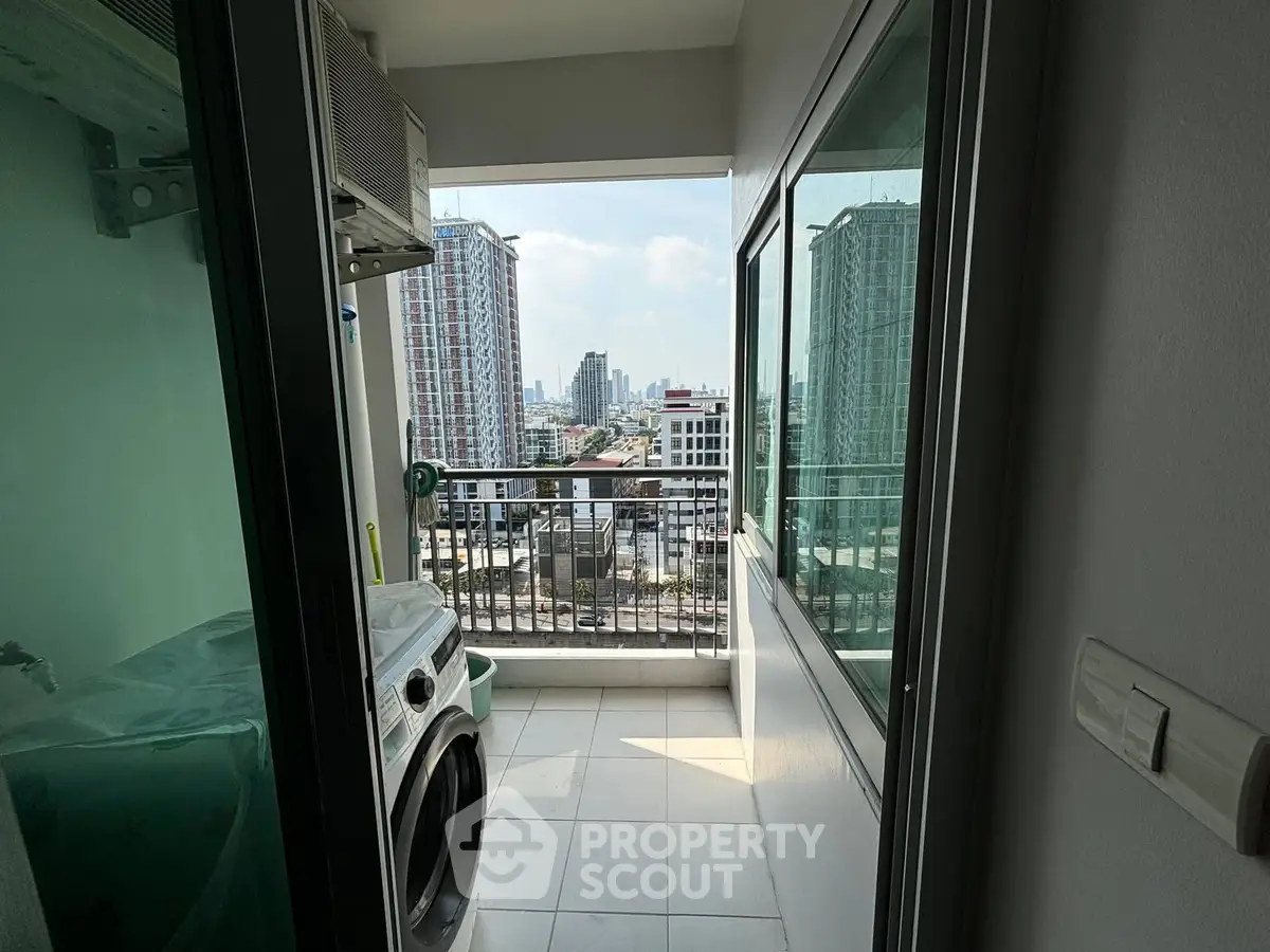 High-rise apartment balcony with city view and washing machine