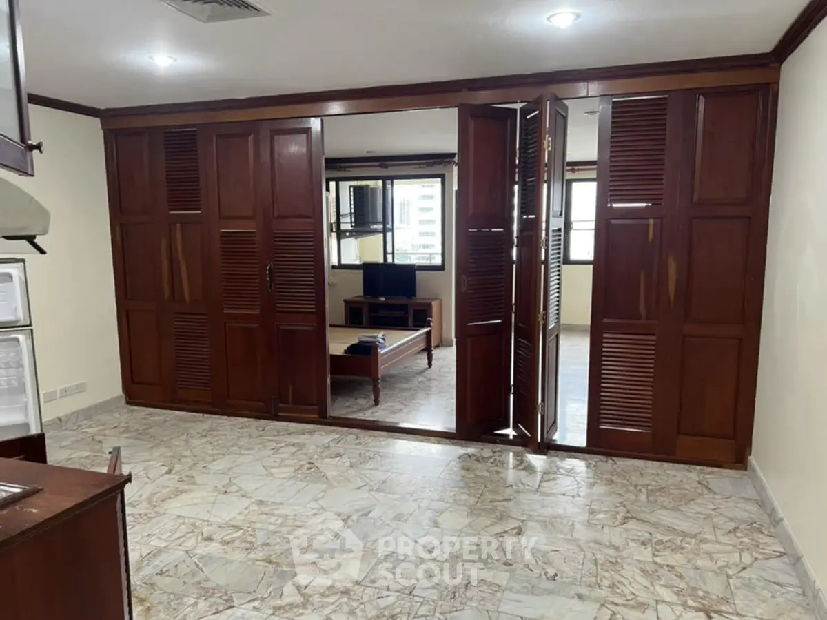 Spacious living room with wooden accents and tiled flooring in urban apartment