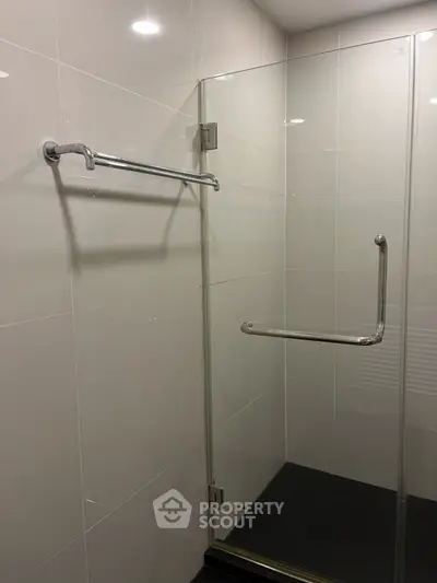 Modern bathroom with glass shower enclosure and sleek chrome fixtures.