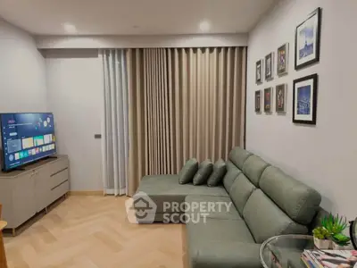 Modern living room with stylish sofa, wall art, and smart TV in a cozy apartment setting.