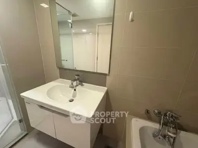 Modern bathroom with sleek vanity and bathtub in contemporary apartment.