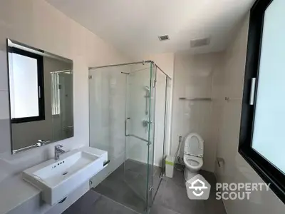 Modern bathroom with glass shower and large window