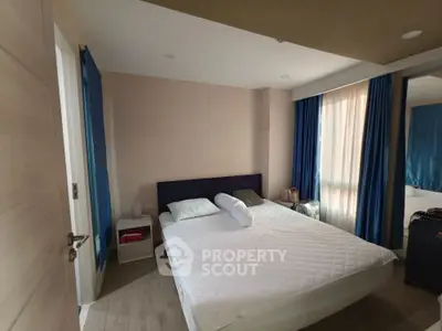 Spacious bedroom with large windows and modern decor in a stylish apartment.