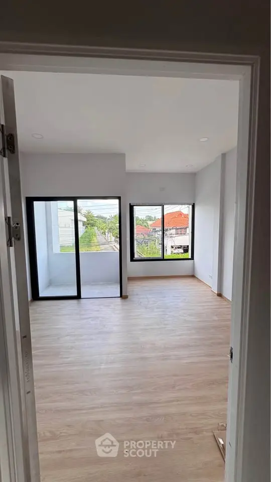 Spacious room with large windows and balcony access, offering abundant natural light and a great view.