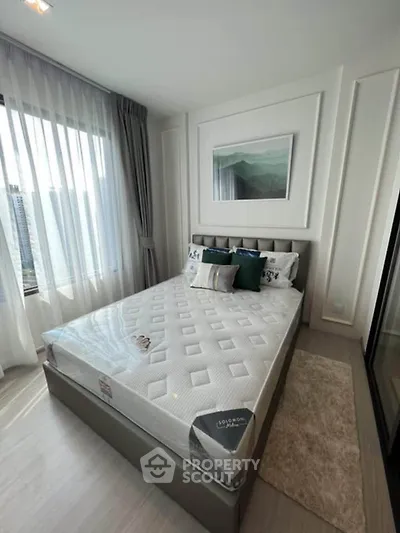 Modern bedroom with large window and stylish decor in a high-rise apartment.