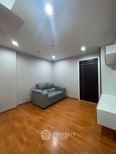 Modern living room with wooden flooring and cozy gray sofa