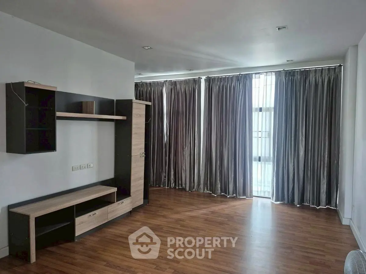 Spacious living room with wooden flooring and modern shelving unit