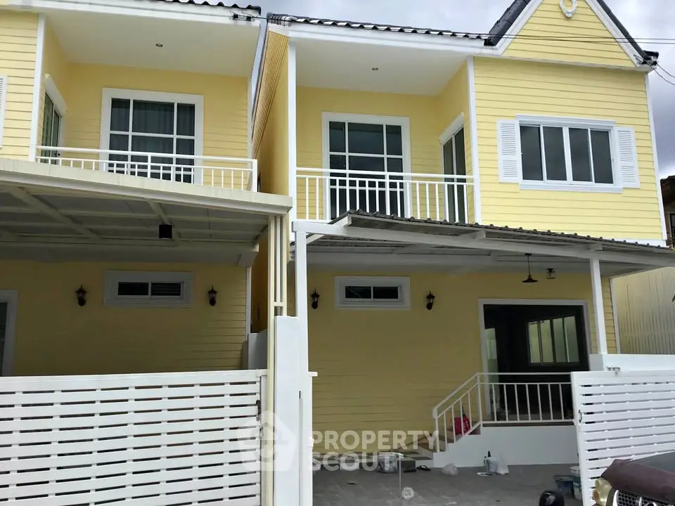 Charming yellow townhouse with modern design and spacious balcony.