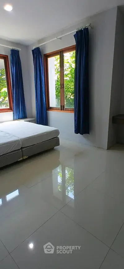 Spacious bedroom with large windows and natural light