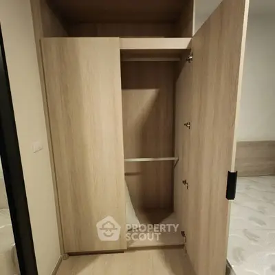 Spacious wooden wardrobe in modern bedroom with open doors showcasing ample storage space.