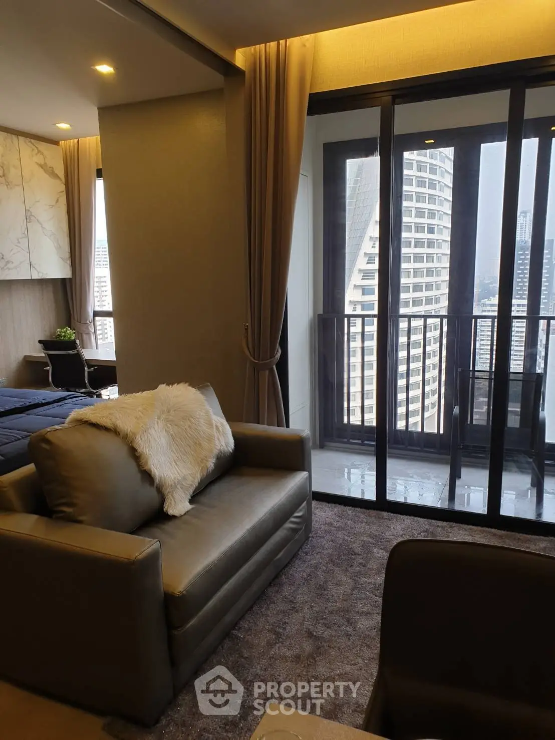 Luxurious living room with modern decor and stunning city view from balcony.