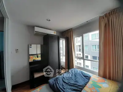 Cozy bedroom with large windows and modern furnishings in a high-rise apartment.