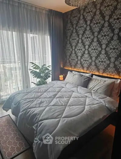 Luxurious bedroom with elegant wallpaper and large window overlooking balcony, perfect for relaxation.