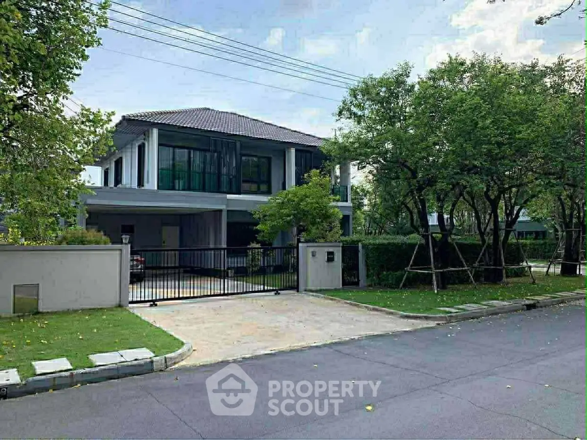 Stunning modern two-story house with lush greenery and spacious driveway in a serene neighborhood.