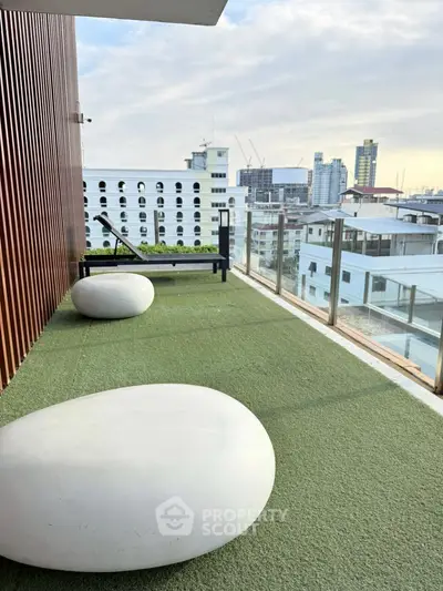 Spacious balcony with artificial grass and city skyline view, perfect for relaxation and outdoor enjoyment.