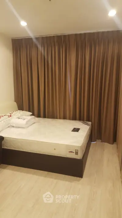 Cozy bedroom with elegant curtains and comfortable bed in modern apartment.