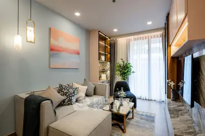 Modern living room with stylish decor, cozy seating, and natural light from large windows.