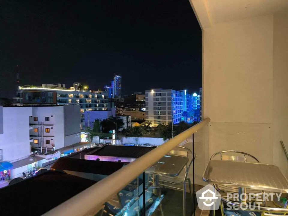 Stunning city view from modern balcony at night with vibrant lights