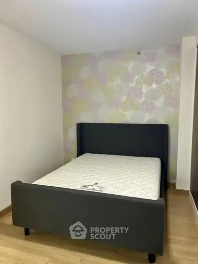 Cozy bedroom with modern bed and stylish wallpaper, perfect for relaxation.