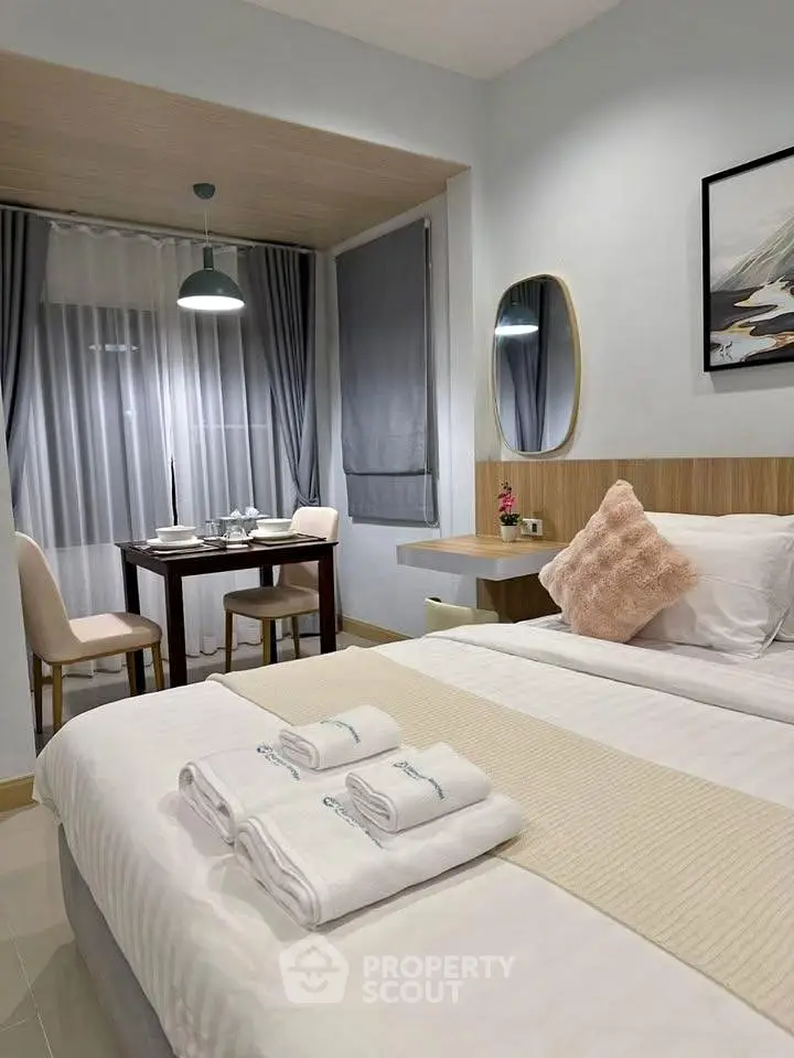 Cozy bedroom with dining nook, modern decor, and soft lighting for a relaxing ambiance.