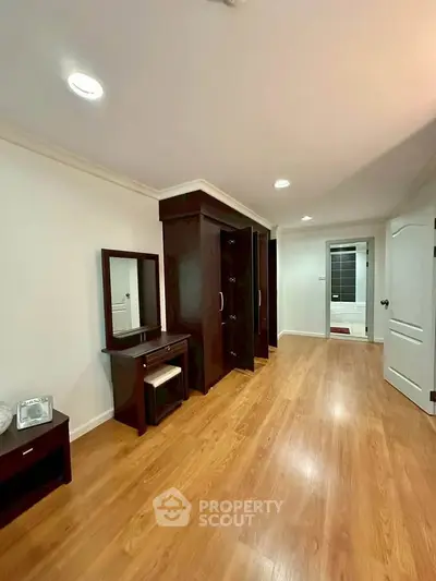 Spacious bedroom with elegant wooden flooring and modern furniture