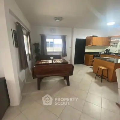 Spacious kitchen with dining area featuring modern appliances and wooden cabinetry.