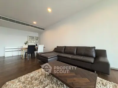 Spacious modern living room with sleek leather sofa and elegant dining area