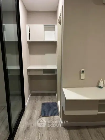 Modern study nook with sleek shelving and wood flooring in a stylish apartment.