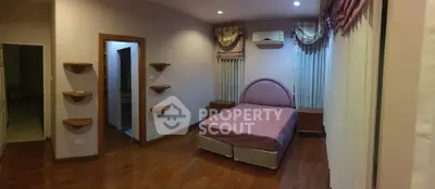 Spacious bedroom with wooden flooring and modern decor