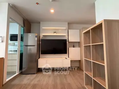 Modern living room with sleek TV unit and spacious shelving in stylish apartment.