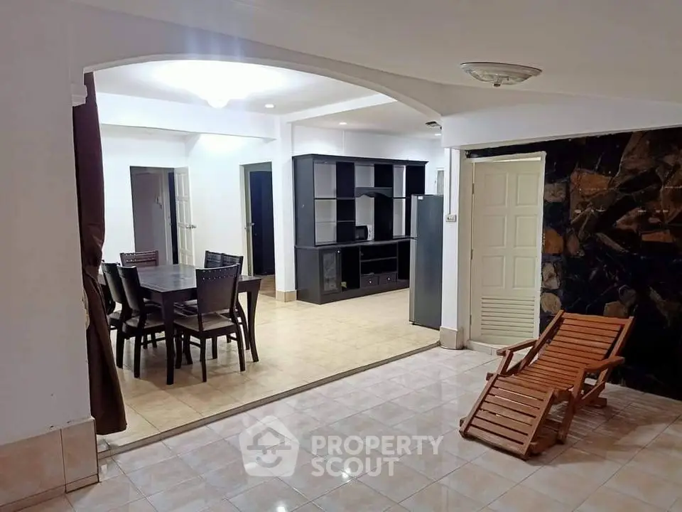 Spacious open-plan living area with dining set and lounge chair, ideal for modern family living.