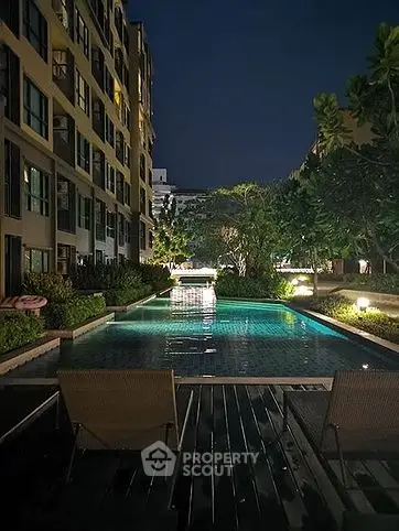 Luxurious night view of a residential pool with ambient lighting and lush greenery.